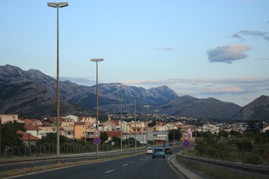 Picturesque view of mountains and highway with cars in city