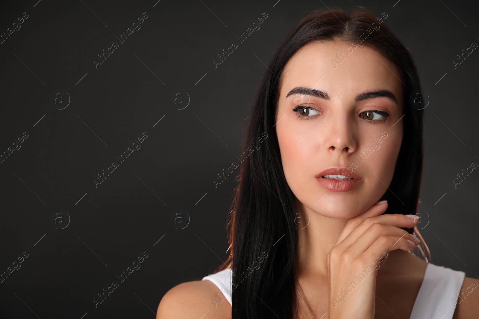 Photo of Portrait of beautiful young woman on black background