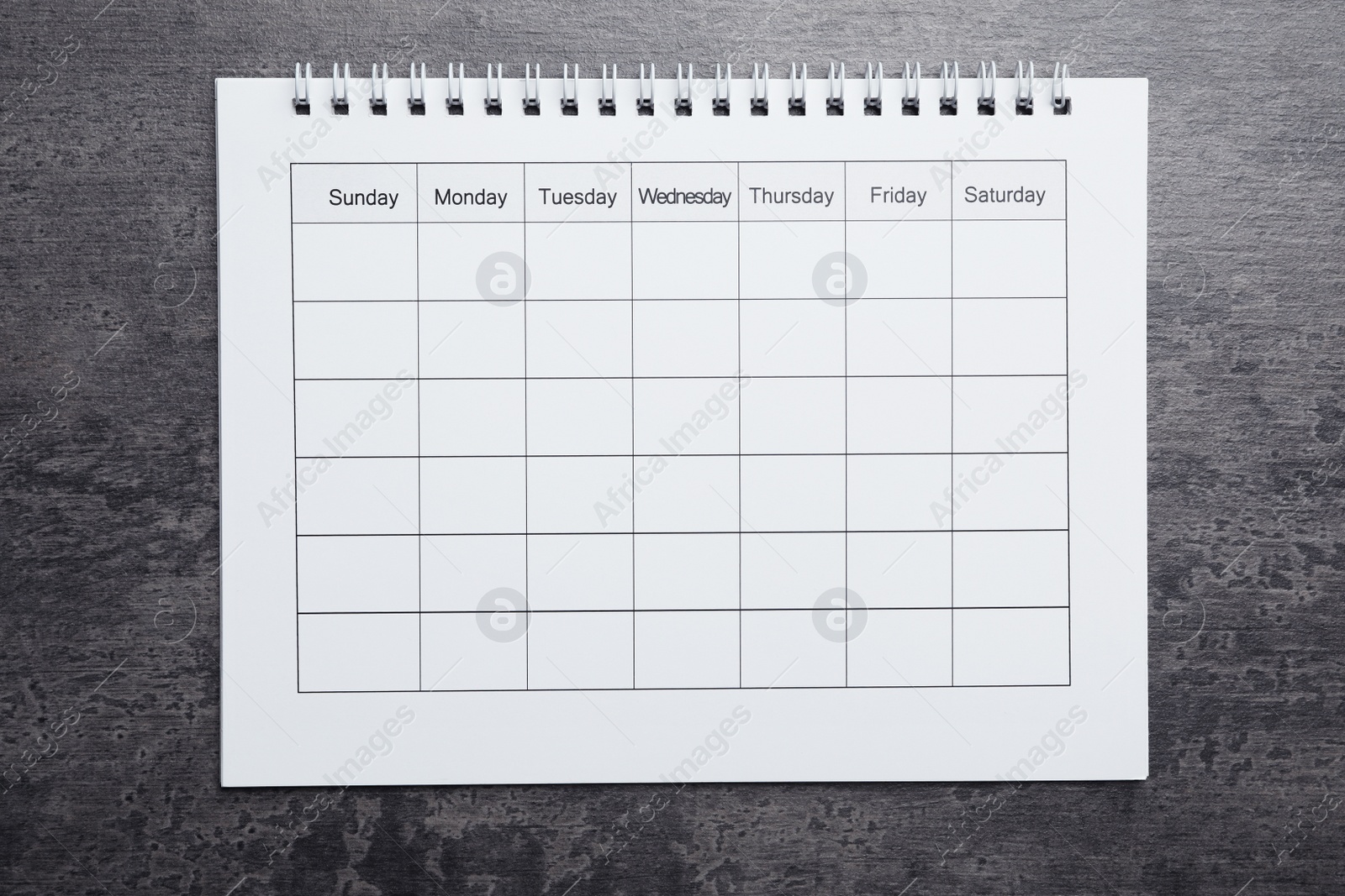 Photo of Blank calendar on grey stone background, top view