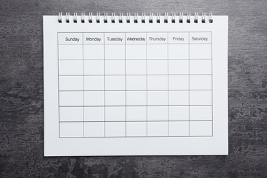 Photo of Blank calendar on grey stone background, top view