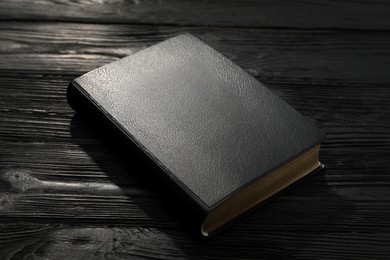 Photo of Bible on black wooden table. Christian religious book
