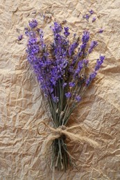 Photo of Bouquet of beautiful lavender flowers on parchment paper, top view