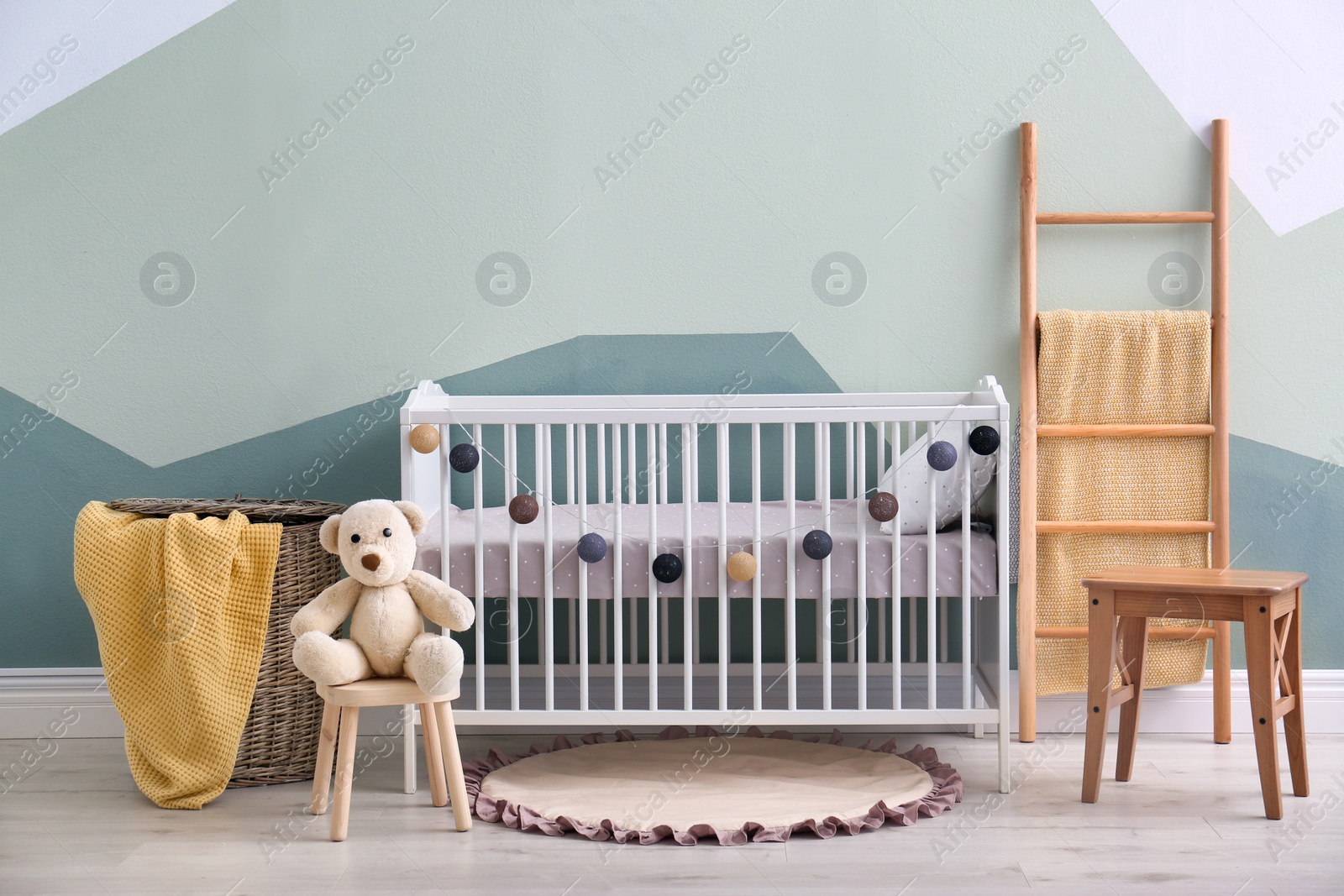 Photo of Baby room interior with crib near wall