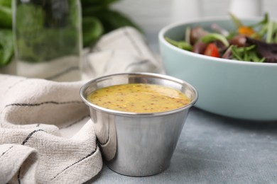 Photo of Tasty vinegar based sauce (Vinaigrette) in bowl on grey table, closeup