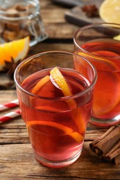 Photo of Aromatic punch drink and ingredients on wooden table