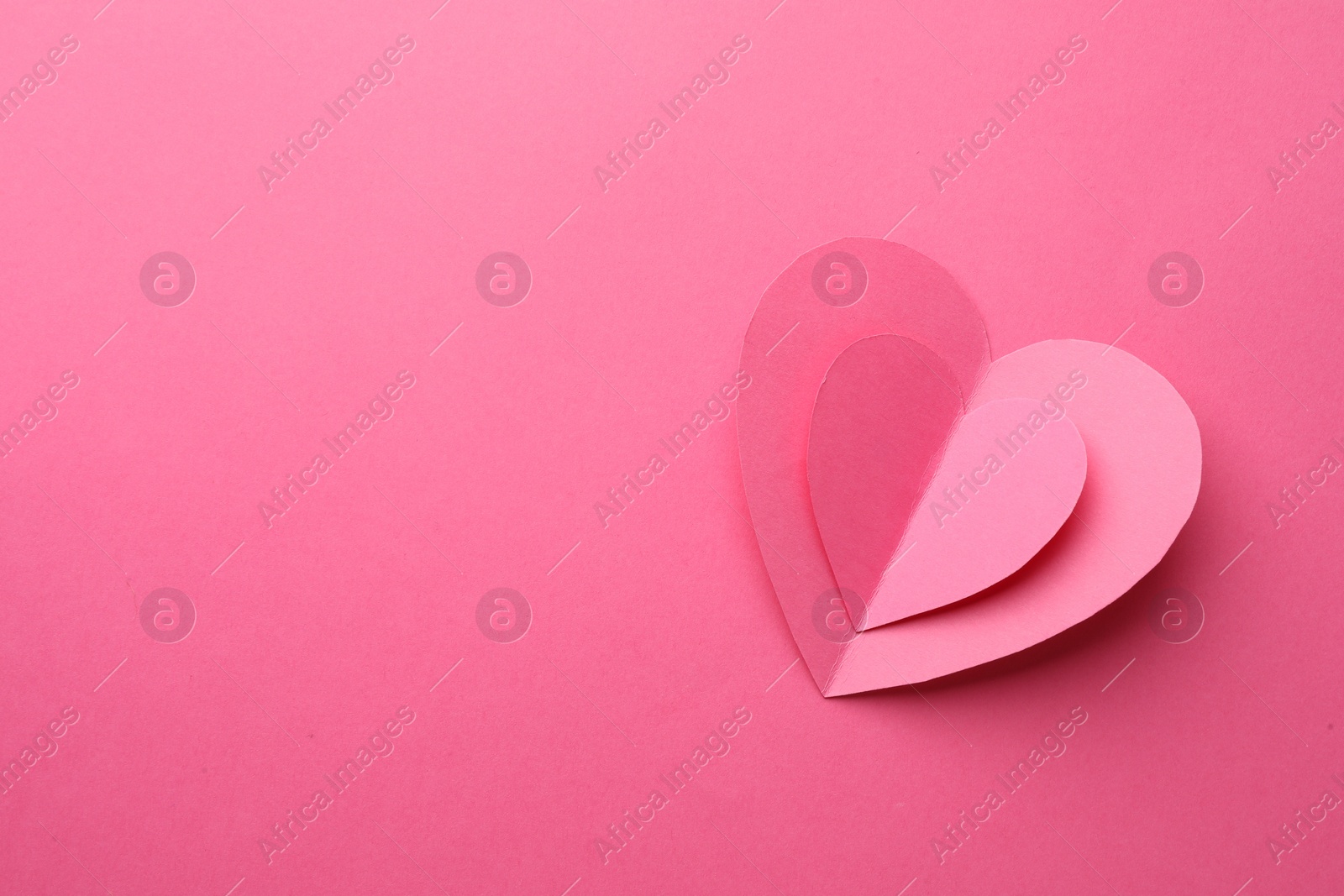 Photo of Paper hearts on pink background, top view. Space for text