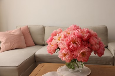 Beautiful pink peonies in vase on table at home, space for text. Interior design