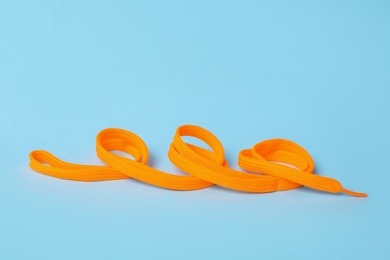 Photo of Orange shoe lace on light blue background