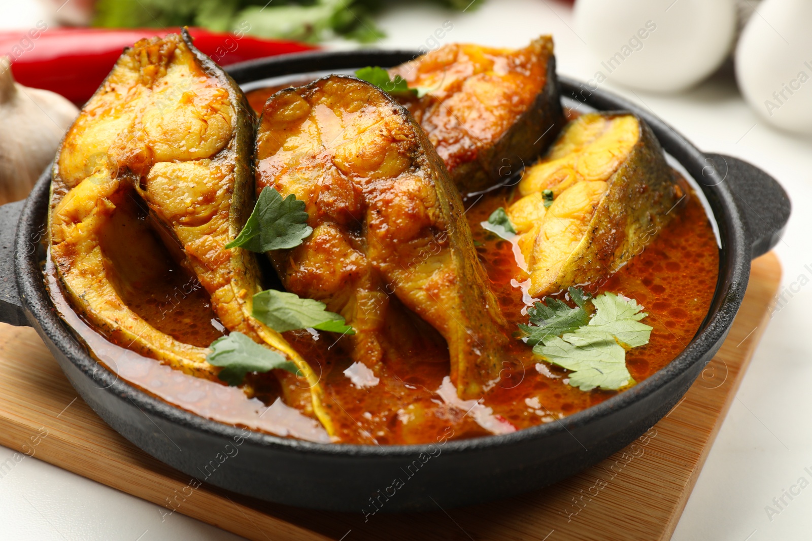 Photo of Tasty fish curry on table, closeup. Indian cuisine