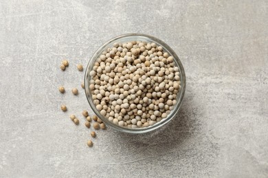 Aromatic spice. White pepper in bowl on light grey table, top view