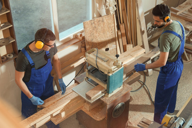 Photo of Professional carpenters working together in shop, view from above