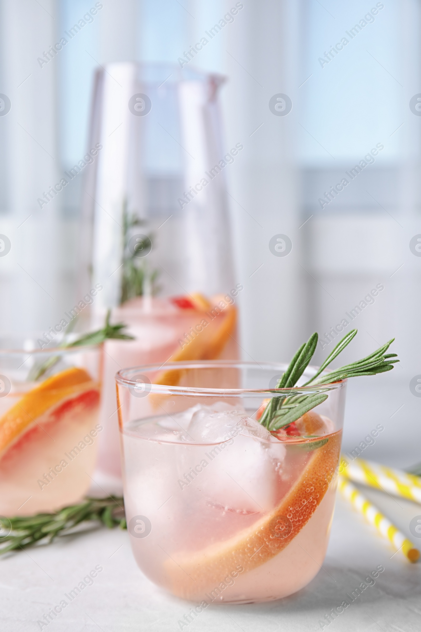 Photo of Refreshing grapefruit cocktail with rosemary on table