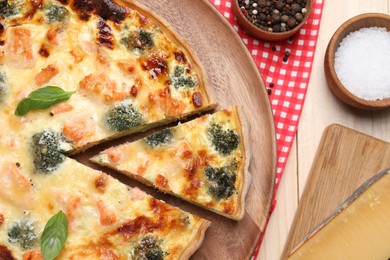 Delicious homemade quiche and ingredients on table, flat lay