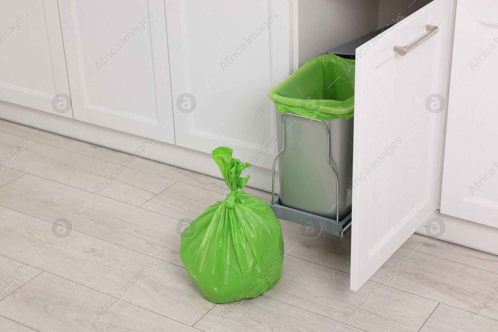 Photo of Plastic garbage bag and trash can indoors. Space for text