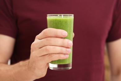 Photo of Man holding glass of delicious smoothie, closeup