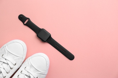 Photo of Stylish smart watch and sneakers on pink background, flat lay. Space for text