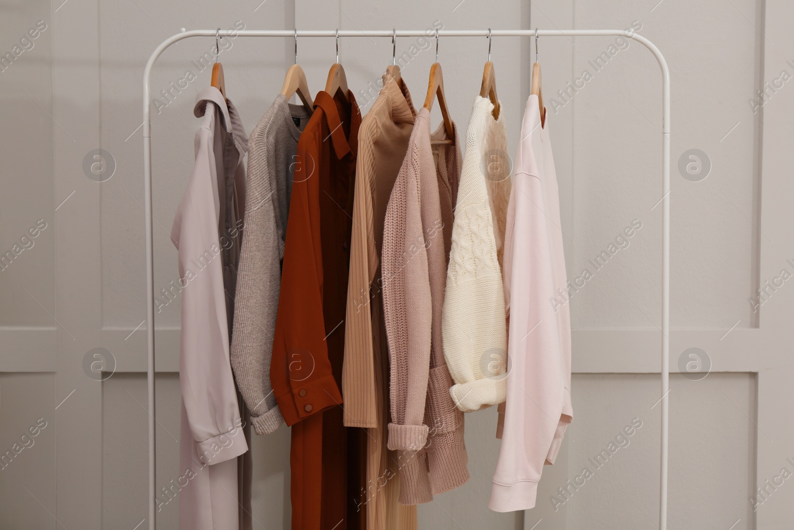 Photo of Rack with different stylish clothes near grey wall