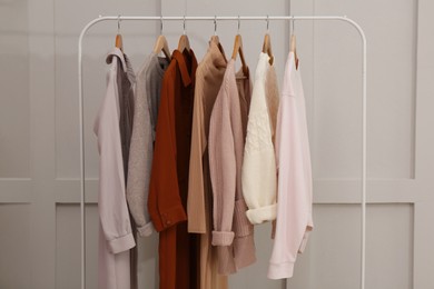 Photo of Rack with different stylish clothes near grey wall