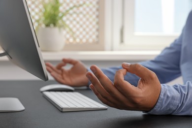 Photo of Businessman meditating at workplace, closeup. Zen concept