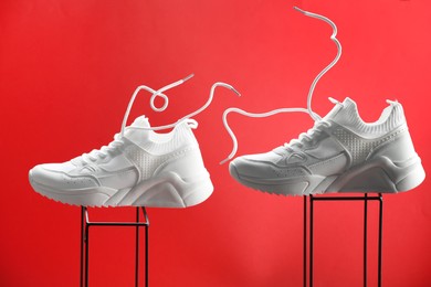 Stylish presentation of white sneakers on red background
