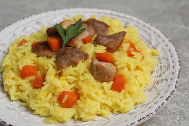Photo of Delicious pilaf with meat served on light grey table, closeup