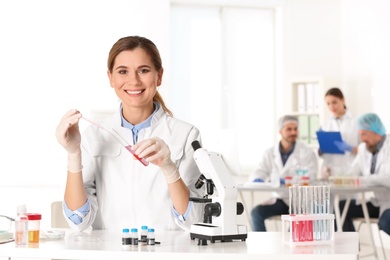 Portrait of female scientist working at table in laboratory, space for text. Research and analysis