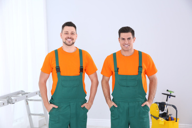 Photo of Team of professional janitors in uniform indoors. Cleaning service