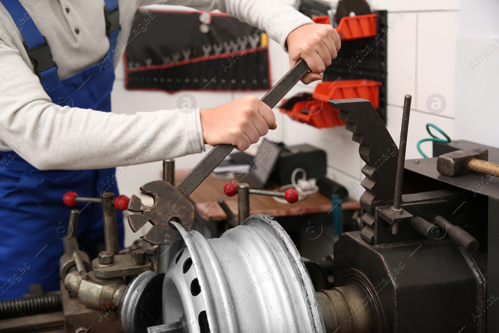 Photo of Mechanic working with car disk lathe machine at tire service, closeup