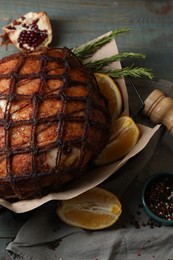 Photo of Delicious baked ham, orange slices and rosemary on table, above view