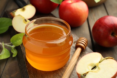 Photo of Sweet honey and fresh apples on wooden table, closeup