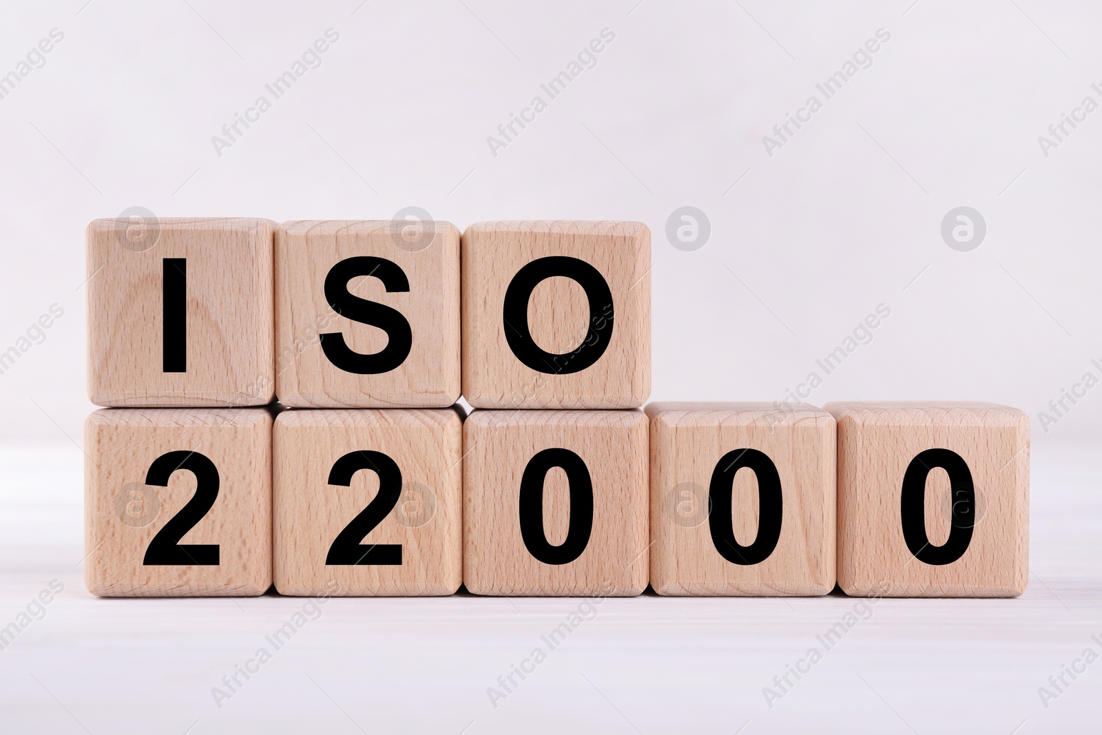 Photo of International Organization for Standardization. Wooden cubes with abbreviation ISO and number 22000 on white table