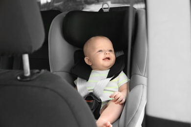 Photo of Little baby in child safety seat inside of car