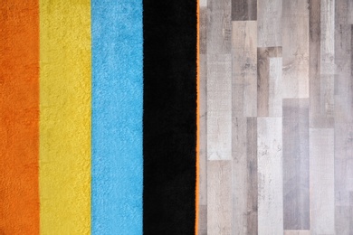 Photo of Colorful striped carpet on wooden floor