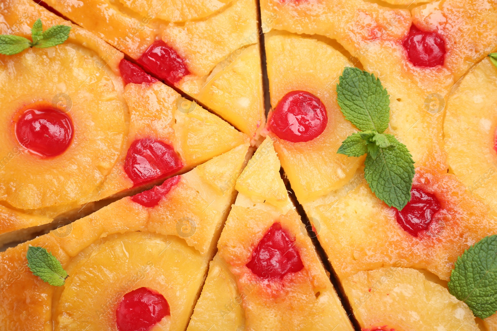 Photo of Delicious cut pineapple pie with cherry and mint as background, top view
