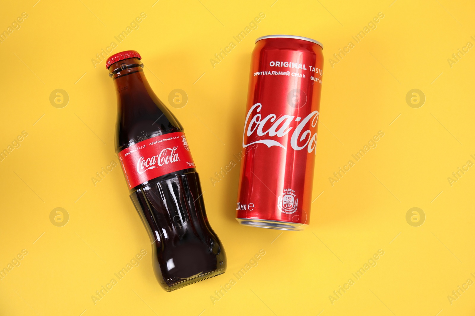 Photo of MYKOLAIV, UKRAINE - NOVEMBER 14, 2018: Can and bottle of Coca-Cola on color background, top view