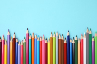 Photo of Colorful wooden pencils on light blue background, flat lay. Space for text