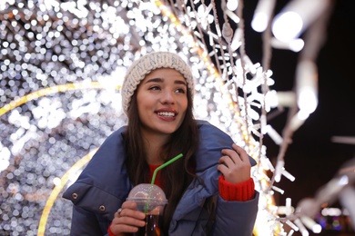 Woman with cup of mulled wine at winter fair