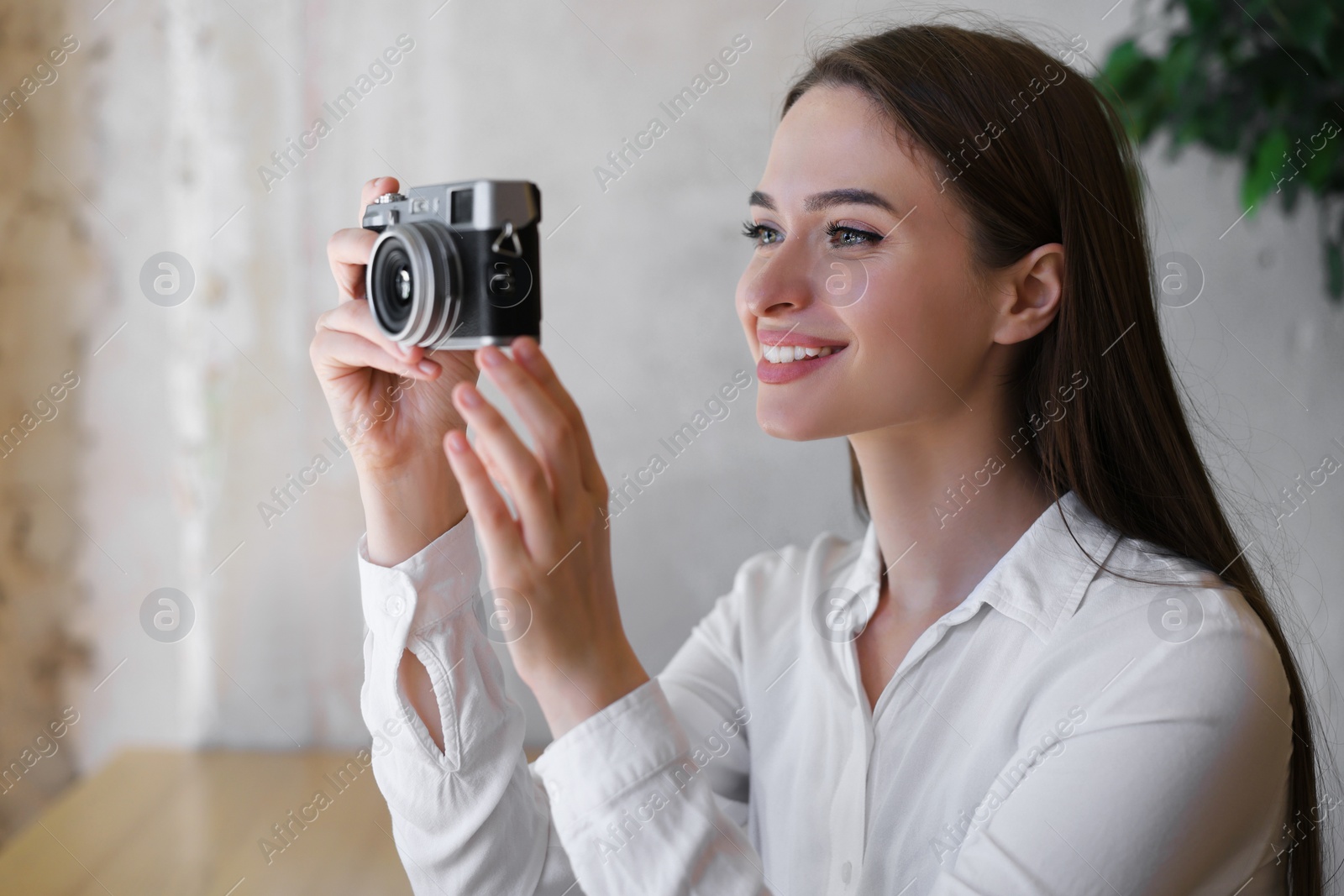 Photo of Young woman taking picture at cafe. Creative hobby