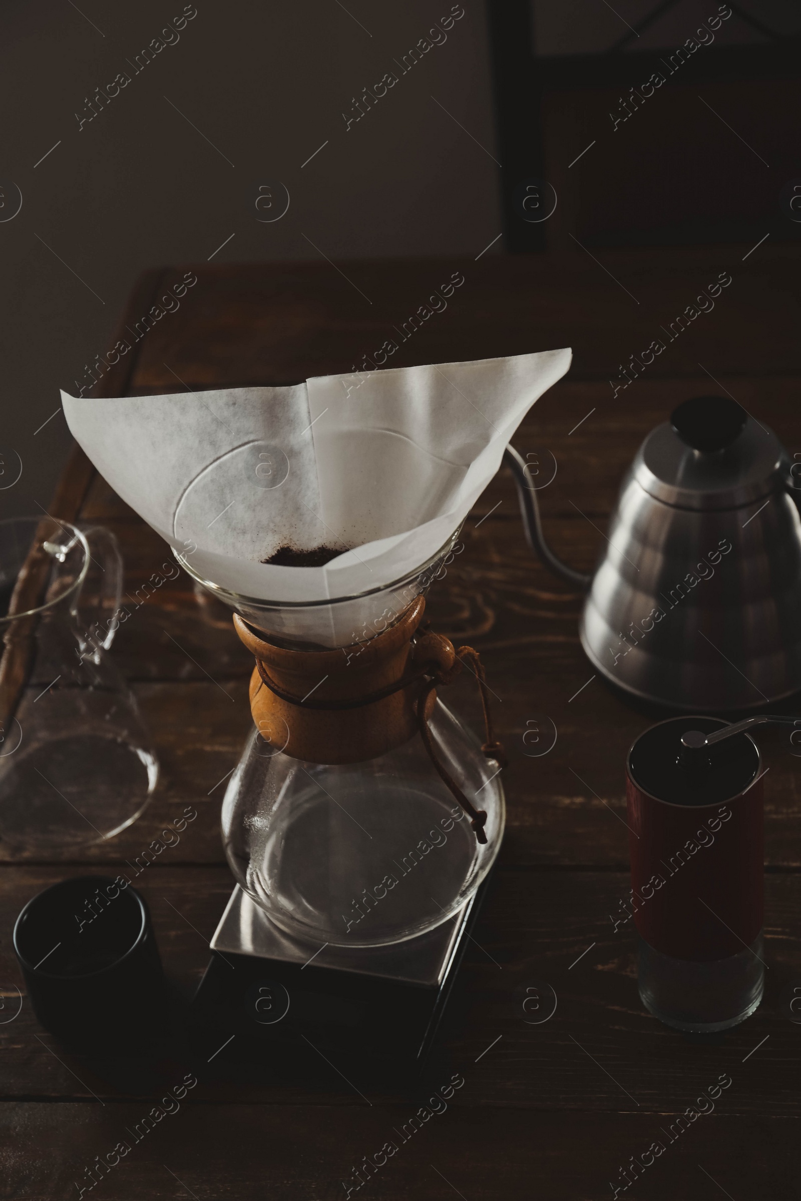 Photo of Coffee maker, grinder and kettle on wooden table in cafe