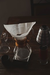 Photo of Coffee maker, grinder and kettle on wooden table in cafe