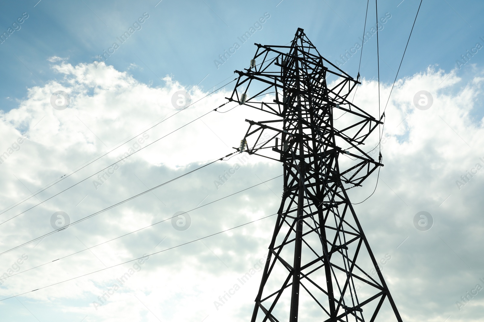 Photo of Telephone pole and wires against blue sky with clouds