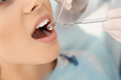 Dentist examining patient's teeth in modern clinic, closeup