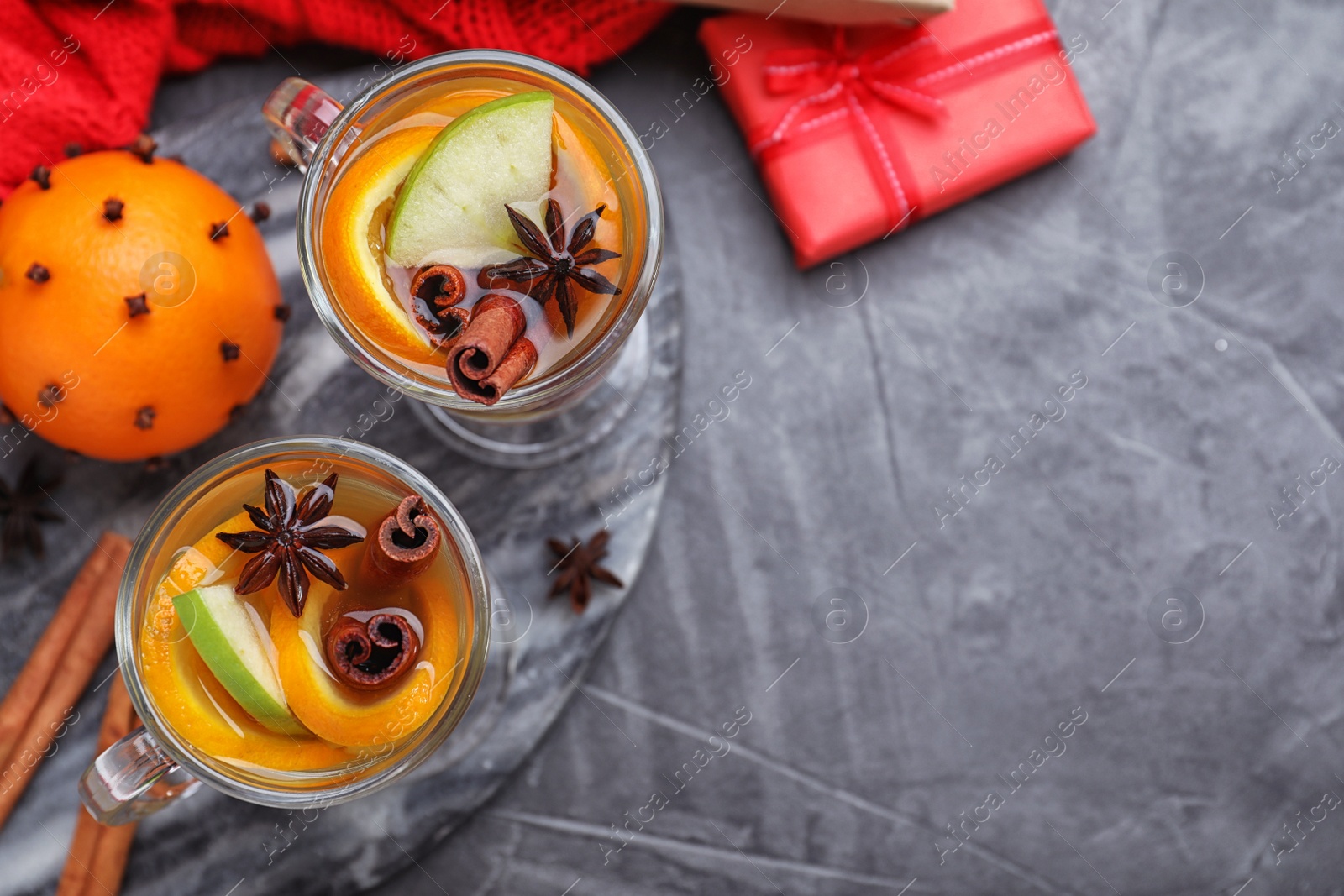 Photo of Aromatic white mulled wine served on grey table, flat lay. Space for text