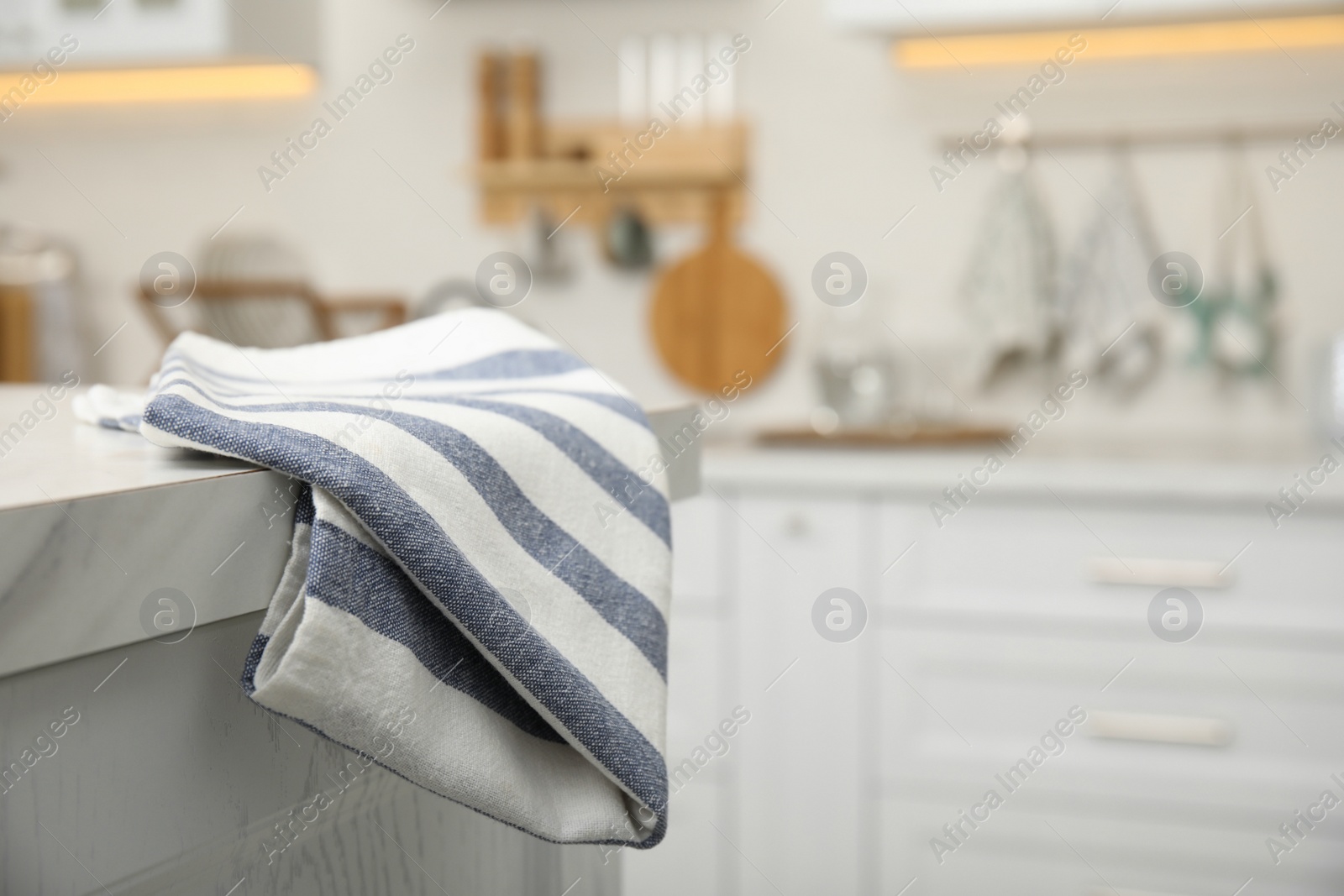 Photo of Clean towel on white marble countertop in kitchen. Space for text