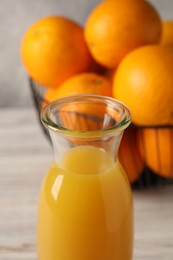 Photo of Tasty fresh oranges and juice in jug on white wooden table, closeup