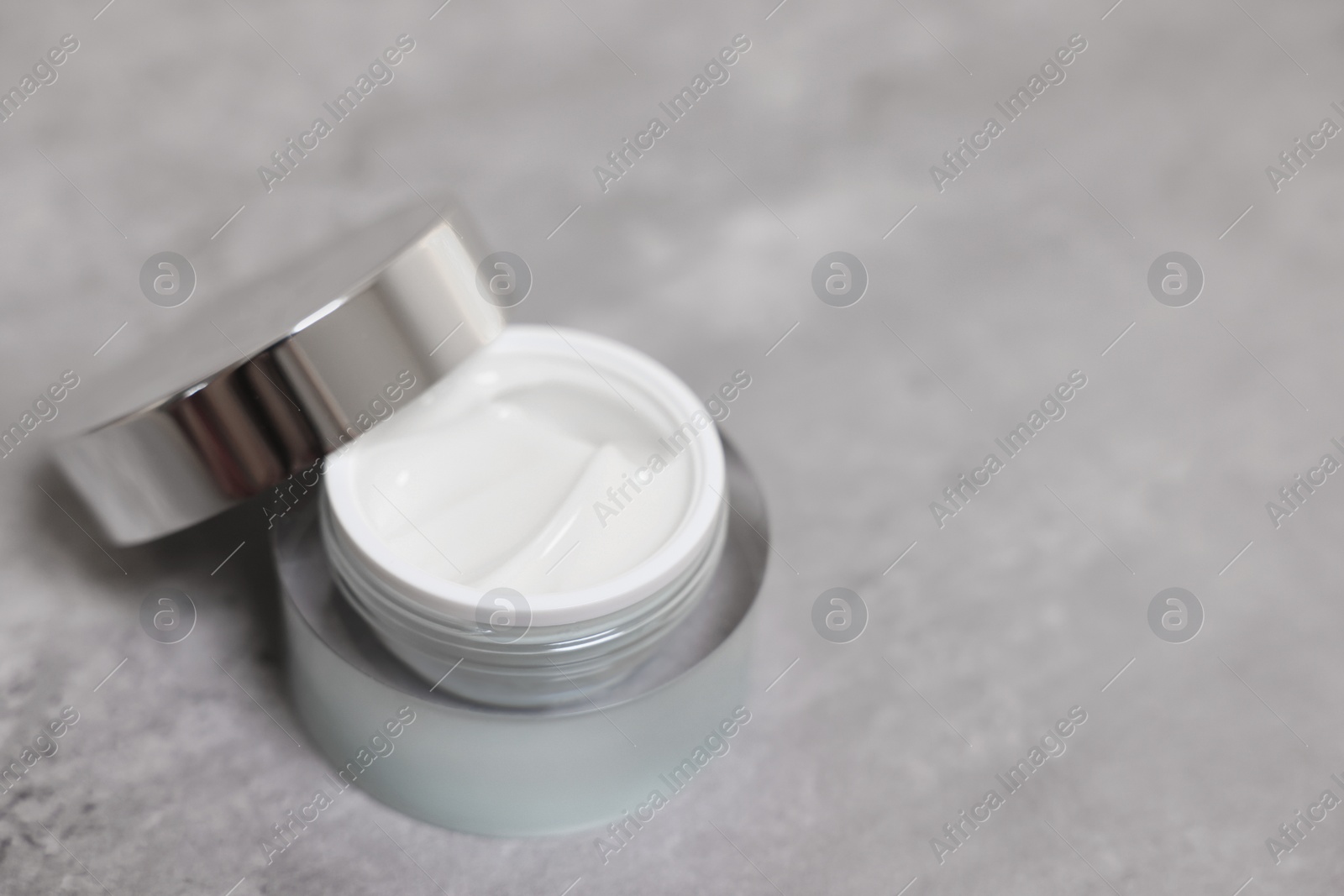 Photo of Body cream on grey table, closeup. Space for text