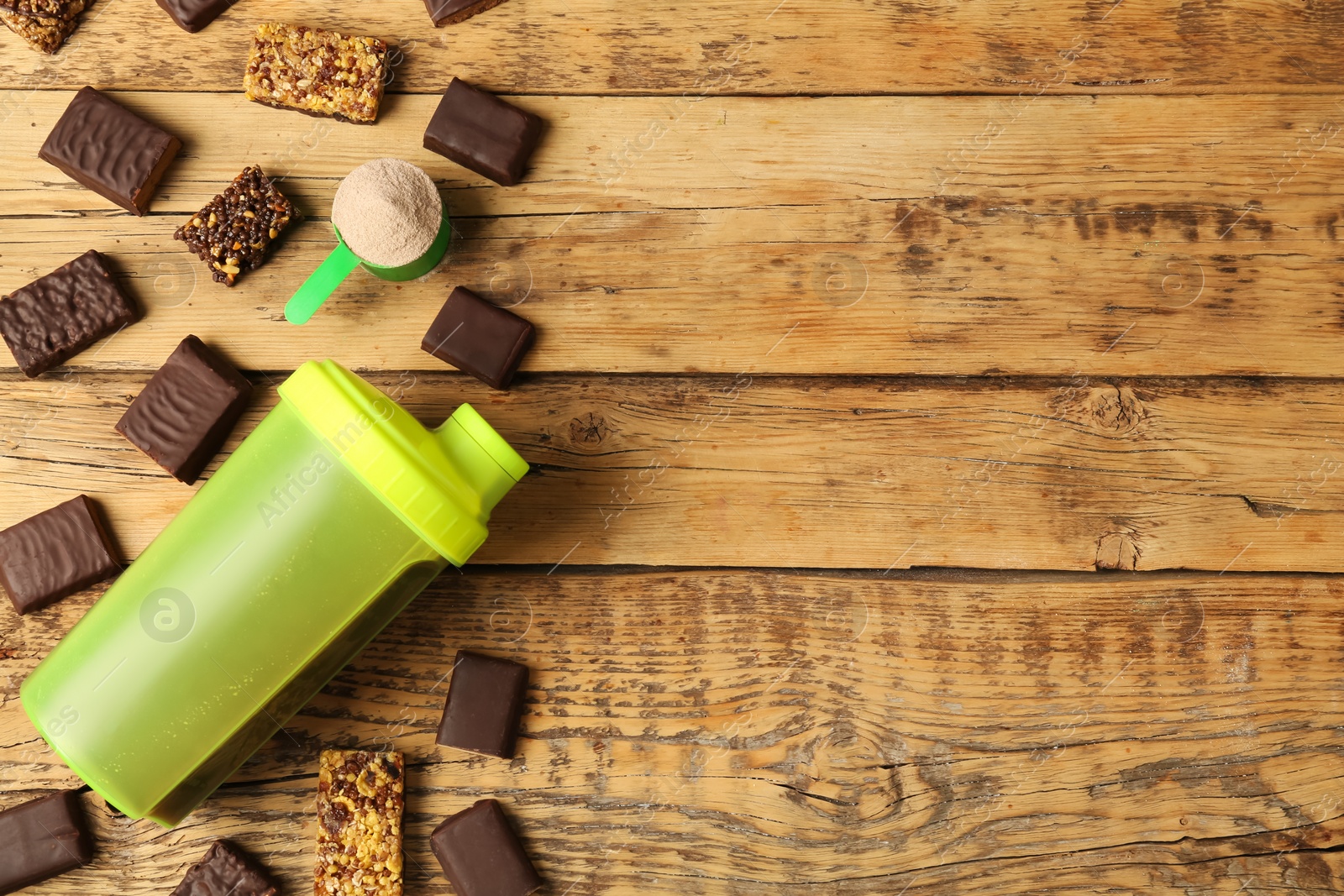 Photo of Different energy bars, protein cocktail and powder on wooden table, flat lay. Space for text