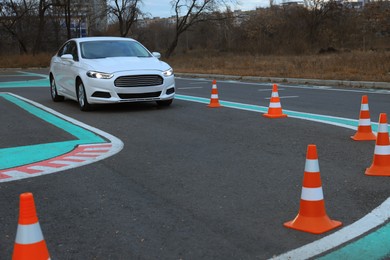 Photo of Modern car on driving school test track with traffic cones