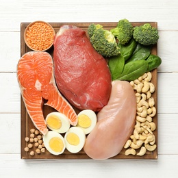 Set of natural food high in protein on wooden background, top view