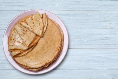 Photo of Delicious crepes on white wooden table, top view. Space for text